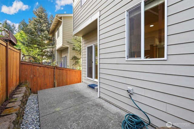 view of side of home with fence and a patio area