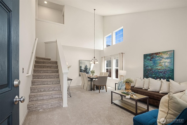 24521 SE 275th St, Maple Valley, WA 98038 - living room with stairway, carpet floors, high vaulted ceiling, baseboards, and a chandelier