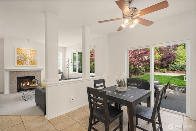 24521 SE 275th St, Maple Valley, WA 98038 - dining area featuring light tile patterned floors, a ceiling fan, a tile fireplace, baseboards, and light colored carpet