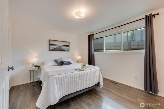 bedroom with wood finished floors and baseboards