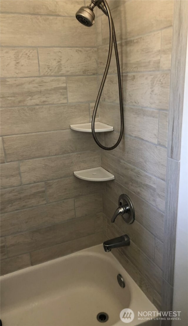 bathroom view of tub / shower combination