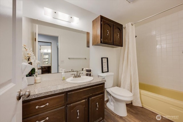 bathroom with toilet, wood finished floors, vanity, and shower / bath combo
