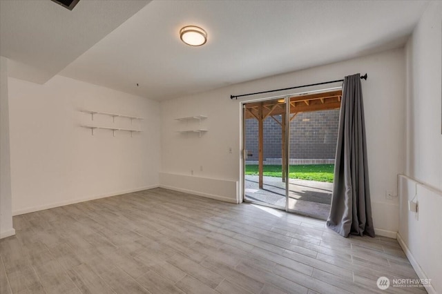 empty room with light wood finished floors and baseboards