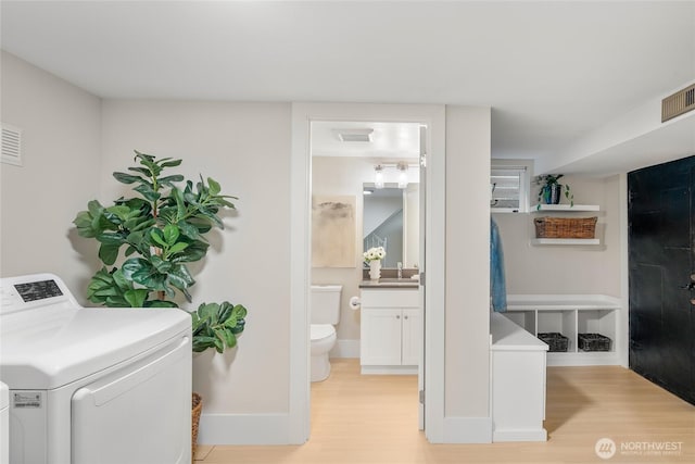 3202 NW 70th St, Seattle, WA 98117 - laundry area with washer / dryer, light wood-style floors, a sink, and baseboards