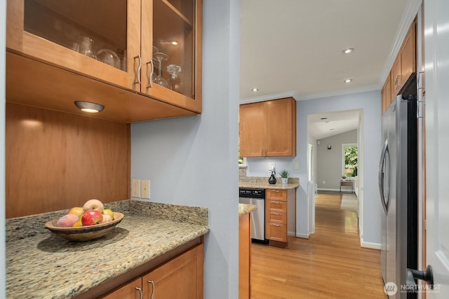 kitchen with stainless steel appliances, light wood-style floors, brown cabinetry, ornamental molding, and light stone counters