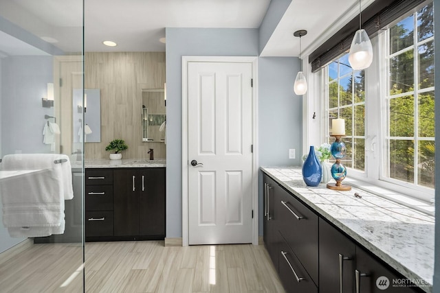 bar area with a sink, hanging light fixtures, and recessed lighting