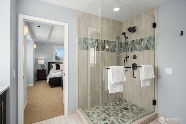 ensuite bathroom with a stall shower, baseboards, and vanity