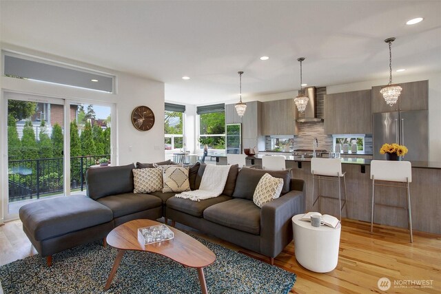 living area featuring light wood-type flooring, plenty of natural light, and recessed lighting
