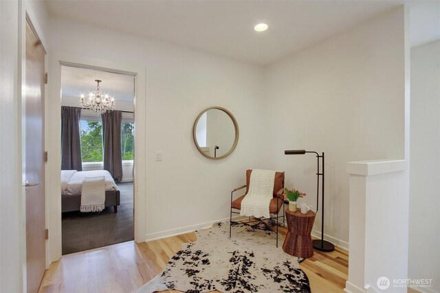 hallway featuring wood finished floors, a chandelier, recessed lighting, and baseboards