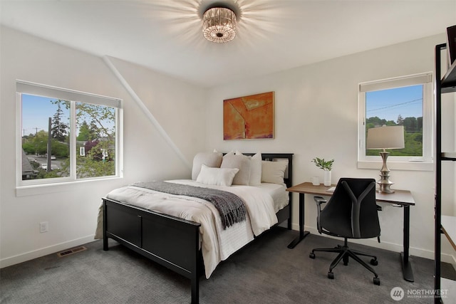 bedroom with dark carpet, baseboards, and a desk