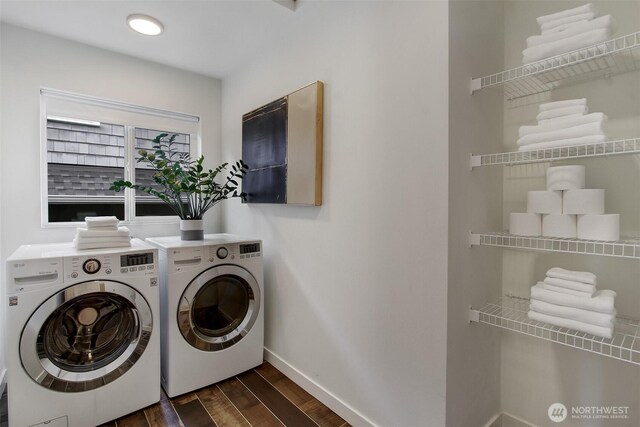 clothes washing area featuring washer and dryer, baseboards, and dark wood finished floors