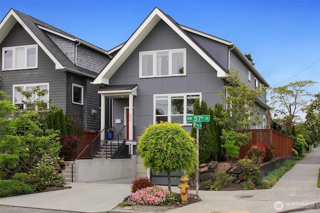 contemporary house featuring fence and roof with shingles