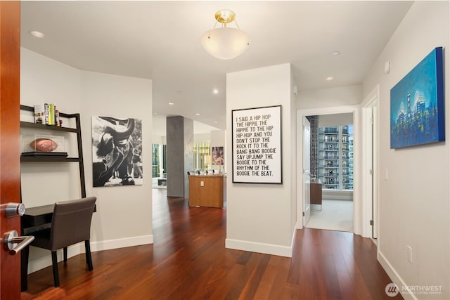 corridor with wood finished floors, baseboards, and recessed lighting