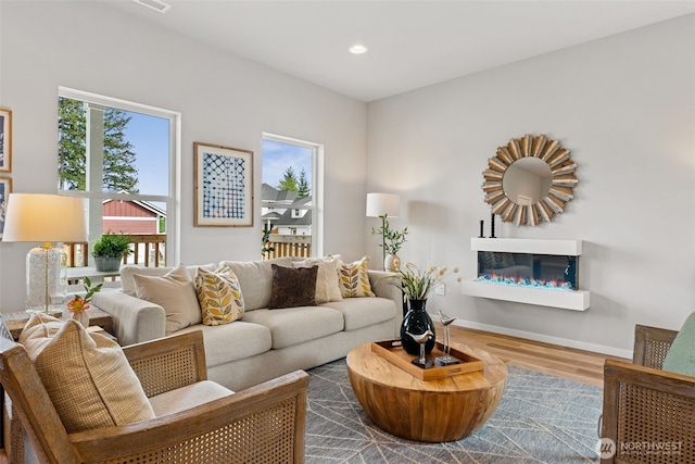 81 E Compass Ln, Allyn, WA 98524 - living area featuring a glass covered fireplace, wood finished floors, recessed lighting, and baseboards