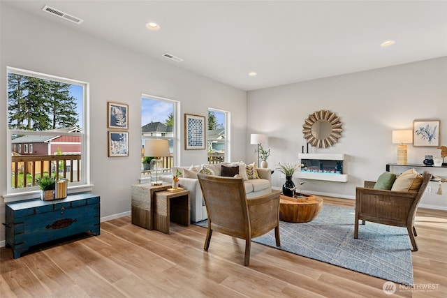 81 E Compass Ln, Allyn, WA 98524 - living room featuring wood finished floors, recessed lighting, a glass covered fireplace, and baseboards