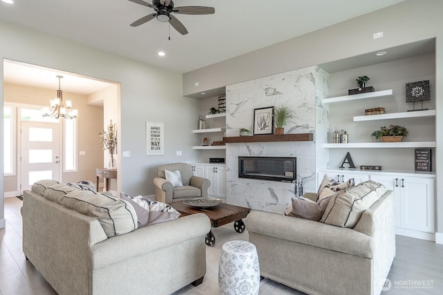 1196 8th Ave NE, Ephrata, WA 98823 - living room featuring built in shelves, a fireplace, a ceiling fan, recessed lighting, and light wood finished floors