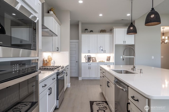 1196 8th Ave NE, Ephrata, WA 98823 - kitchen with stainless steel appliances, a sink, white cabinets, light countertops, and light wood finished floors