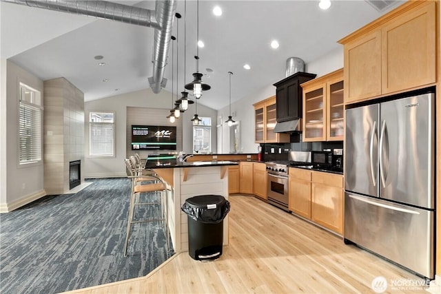 13405 97th Ave E Unit 107, Puyallup, WA 98373 - kitchen with appliances with stainless steel finishes, light wood-style flooring, light brown cabinetry, a kitchen breakfast bar, and dark countertops