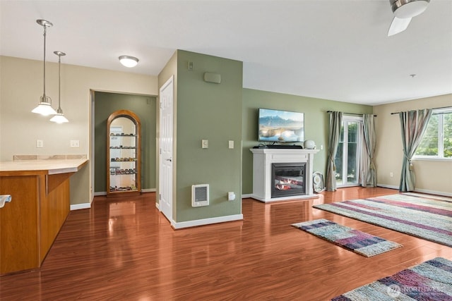 13405 97th Ave E Unit 107, Puyallup, WA 98373 - unfurnished living room featuring wood finished floors, baseboards, a glass covered fireplace, and ceiling fan