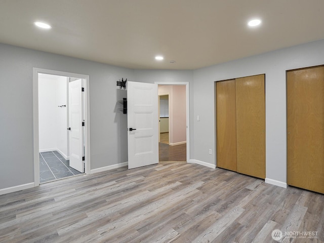 1307 SW 355th Pl, Federal Way, WA 98023 - unfurnished bedroom featuring wood finished floors, multiple closets, recessed lighting, ensuite bath, and baseboards