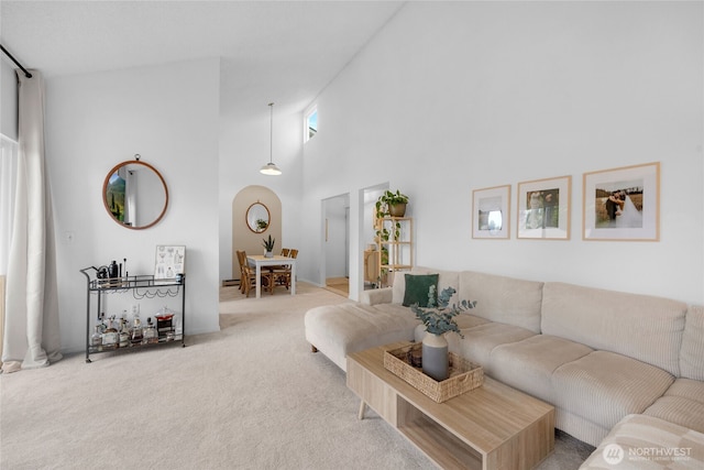 carpeted living area with a high ceiling