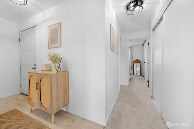 corridor featuring baseboards and light wood-style floors