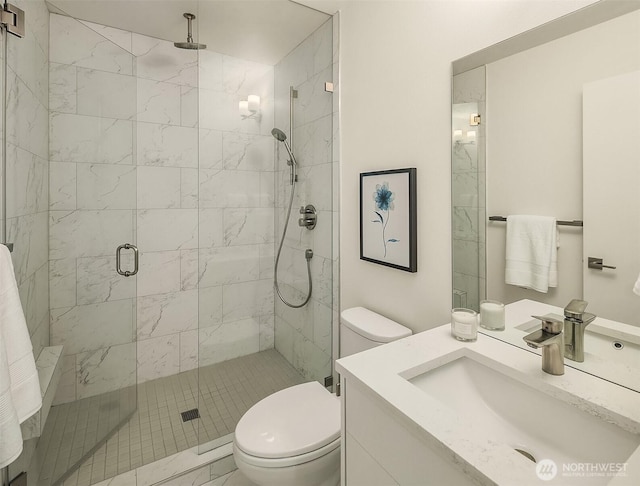 bathroom with toilet, a stall shower, and vanity
