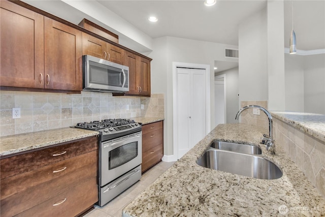 15408 Main St Unit 401, Mill Creek, WA 98012 - kitchen with appliances with stainless steel finishes, a sink, light stone countertops, and tasteful backsplash