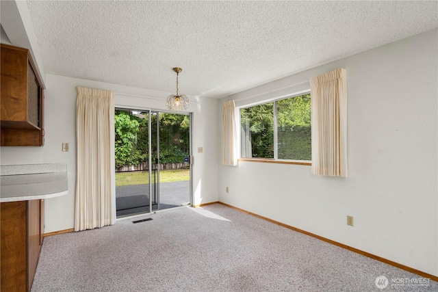 4414 Merlie Ave NE, Bremerton, WA 98310 - unfurnished dining area featuring carpet, baseboards, a textured ceiling, and a chandelier