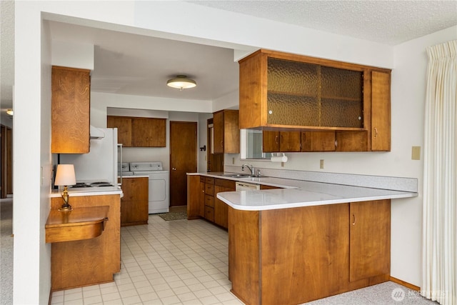 4414 Merlie Ave NE, Bremerton, WA 98310 - kitchen featuring brown cabinets, freestanding refrigerator, washer and clothes dryer, a peninsula, and a sink