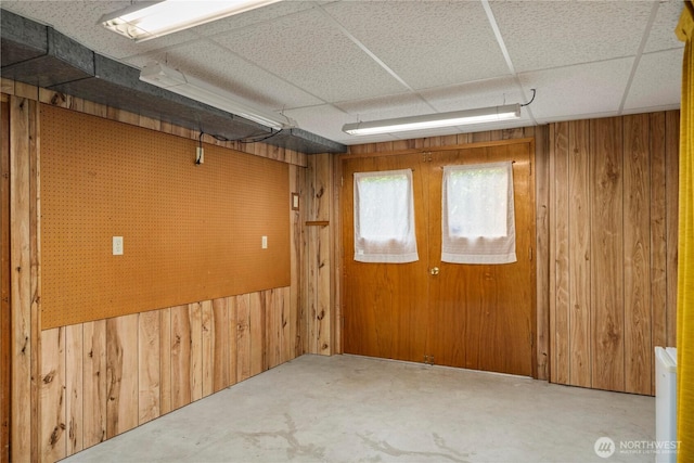 4414 Merlie Ave NE, Bremerton, WA 98310 - unfurnished room with wood walls, unfinished concrete flooring, and a paneled ceiling