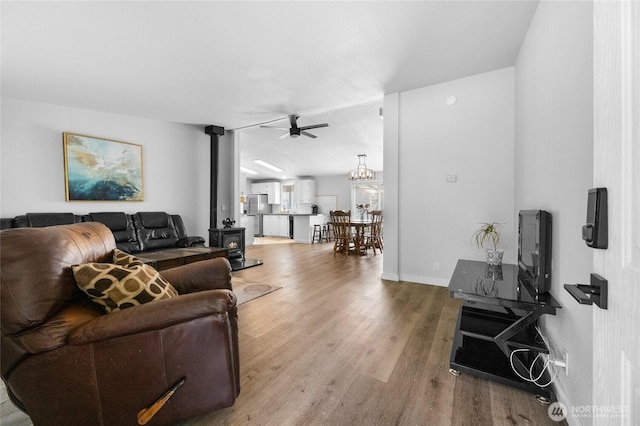 16037 Vail Loop Rd SE, Rainier, WA 98576 - living room featuring a wood stove, wood finished floors, ceiling fan, and baseboards