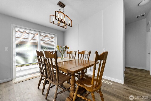 16037 Vail Loop Rd SE, Rainier, WA 98576 - dining space featuring wood finished floors, a chandelier, and baseboards