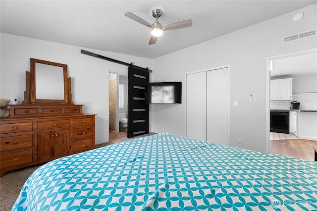 16037 Vail Loop Rd SE, Rainier, WA 98576 - bedroom with a barn door, a closet, a ceiling fan, and wood finished floors