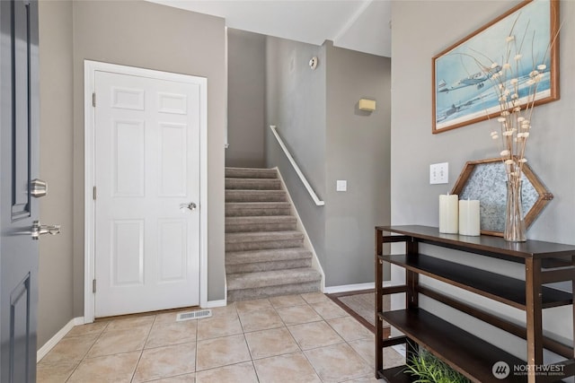 staircase with baseboards and tile patterned flooring