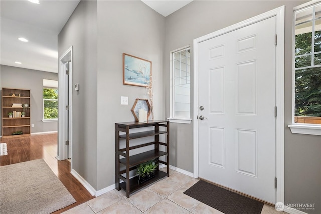 foyer featuring light wood finished floors, baseboards, and recessed lighting