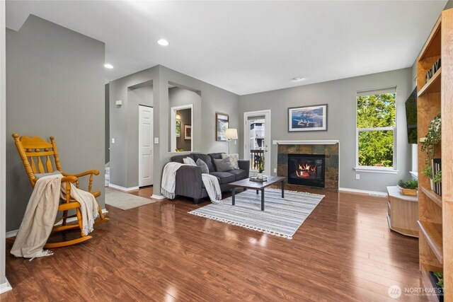 living room with a tiled fireplace, baseboards, wood finished floors, and recessed lighting