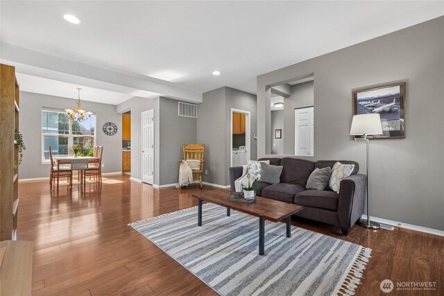 living room with a chandelier, baseboards, wood finished floors, and recessed lighting