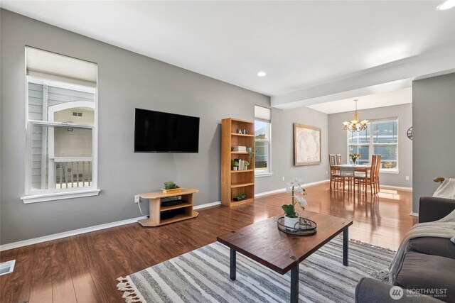 living area featuring a chandelier, wood finished floors, baseboards, and recessed lighting