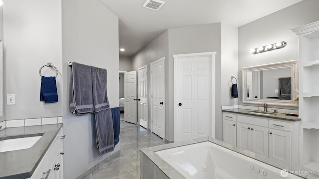207 Clayton Pl, Mattawa, WA 99349 - bathroom featuring marble look tile flooring, two vanities, a tub with jets, and recessed lighting