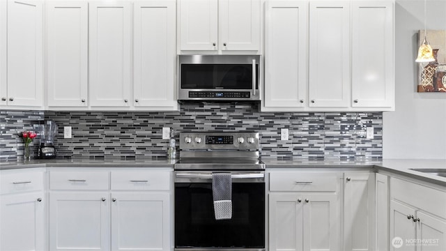 207 Clayton Pl, Mattawa, WA 99349 - kitchen with stainless steel appliances, white cabinets, and decorative backsplash