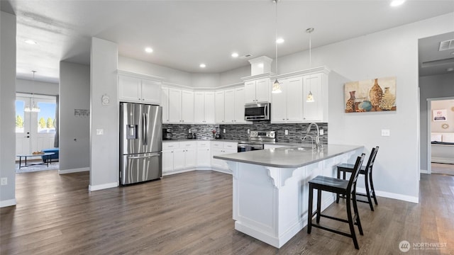 207 Clayton Pl, Mattawa, WA 99349 - kitchen with stainless steel appliances, a peninsula, a sink, backsplash, and a breakfast bar area