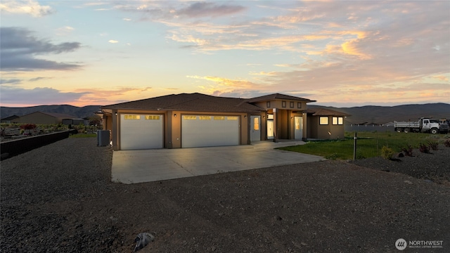 207 Clayton Pl, Mattawa, WA 99349 - prairie-style home featuring concrete driveway, an attached garage, a mountain view, cooling unit, and stucco siding