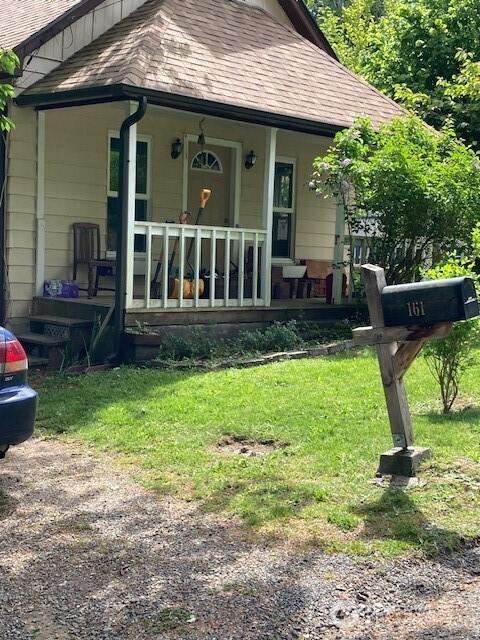 161 N Schoolhouse Hill Rd, Hoodsport, WA 98548 - rear view of property with a porch, a shingled roof, and a lawn