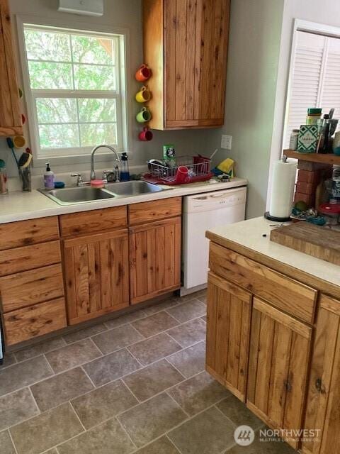 161 N Schoolhouse Hill Rd, Hoodsport, WA 98548 - kitchen featuring a sink, white dishwasher, light countertops, stone finish flooring, and brown cabinetry