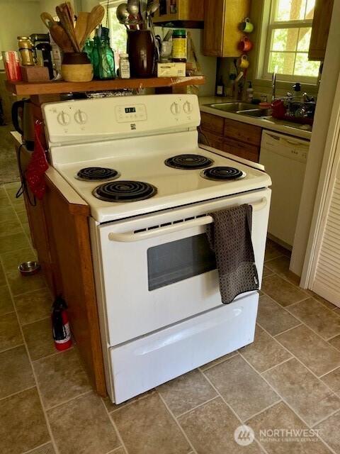 161 N Schoolhouse Hill Rd, Hoodsport, WA 98548 - kitchen with white appliances, brown cabinetry, and tile patterned floors
