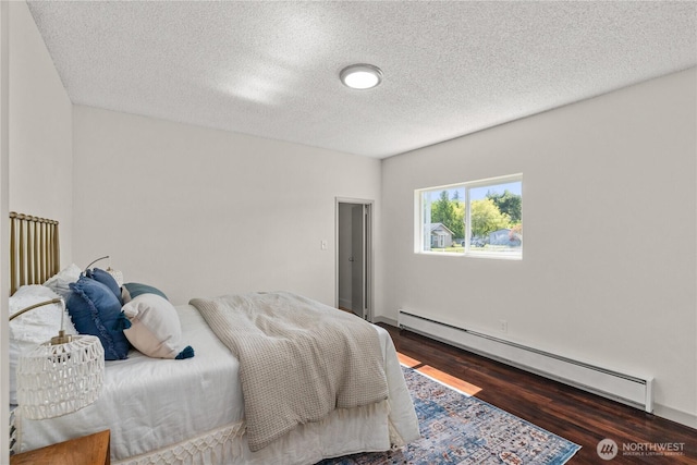 506 G St, Cosmopolis, WA 98537 - bedroom with a baseboard radiator, wood finished floors, and a textured ceiling