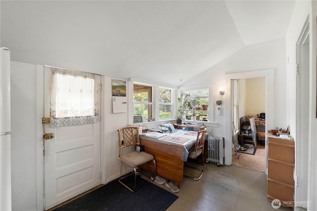 office space with vaulted ceiling, radiator, and tile patterned floors