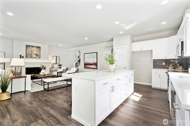 16636 8th Avenue Ct E Unit 05, Spanaway, WA 98387 - kitchen with stainless steel microwave, dark wood finished floors, open floor plan, recessed lighting, and decorative backsplash