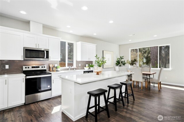 16636 8th Avenue Ct E Unit 05, Spanaway, WA 98387 - kitchen featuring appliances with stainless steel finishes, a sink, healthy amount of natural light, a breakfast bar, and recessed lighting